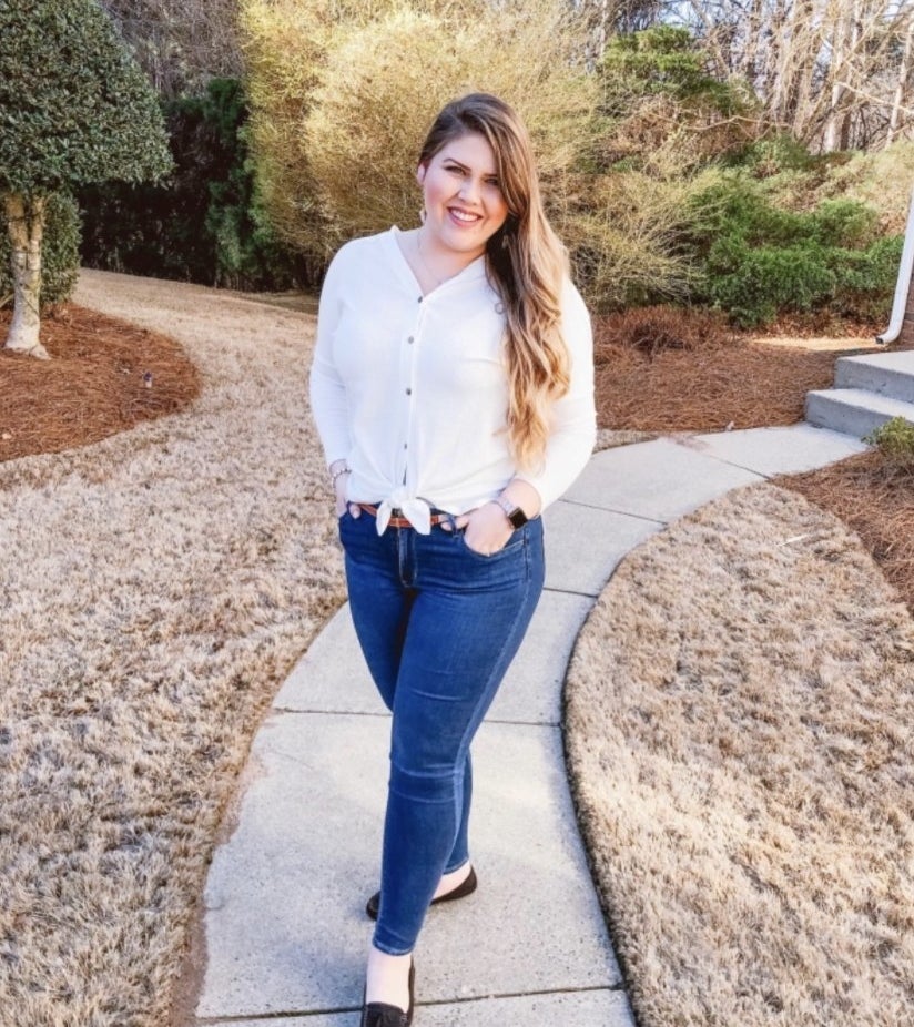 A reviewer wearing the dark blue jeans with a white button-down