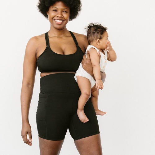 model wearing black bra, holding baby
