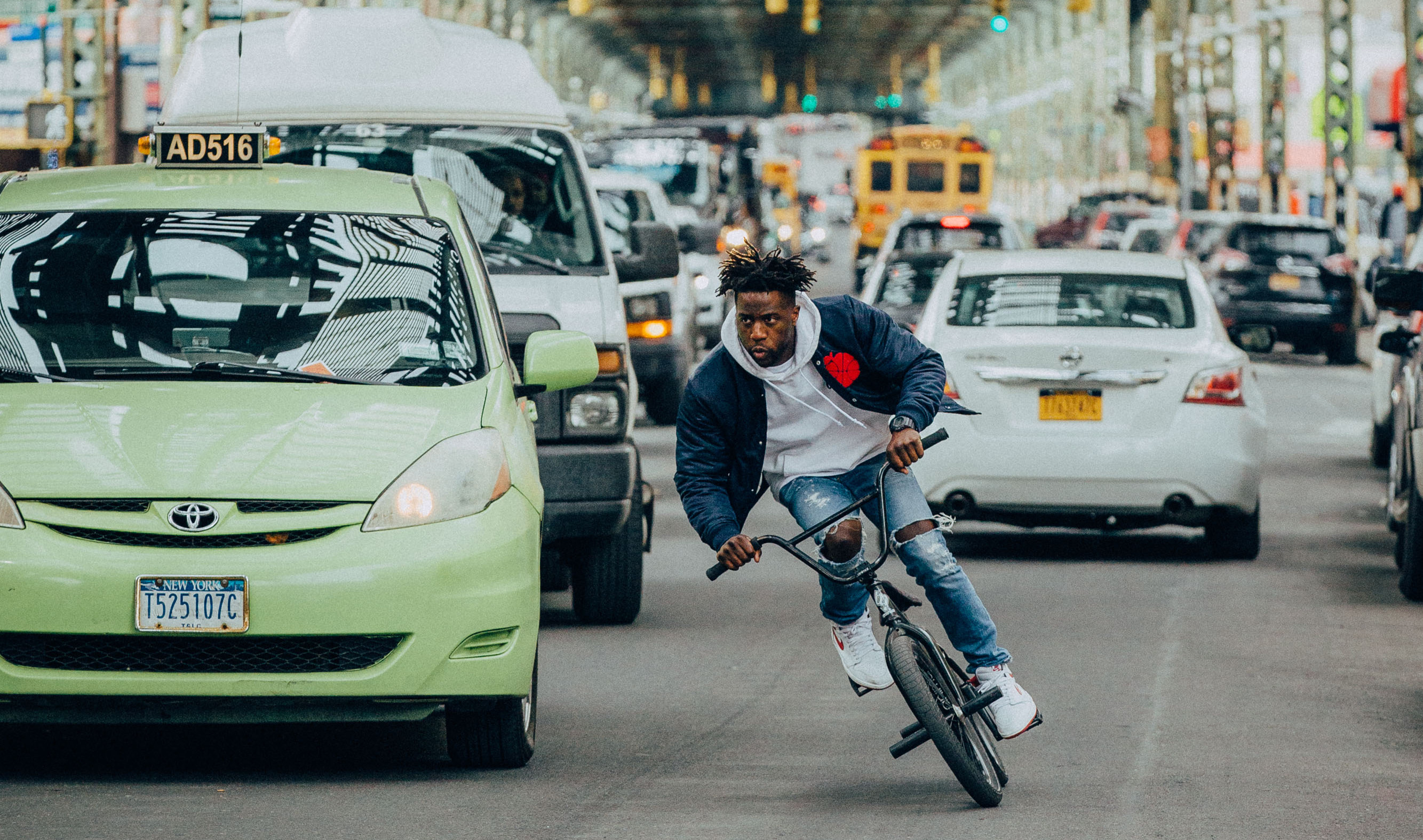 Professional BMX rider Nigel Sylvester rides through a busy street
