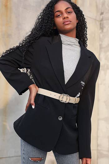 model wearing the belt in tan over a black blazer