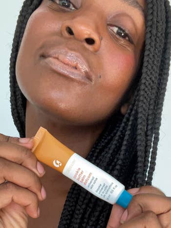 model wearing the lip balm and holding the tube