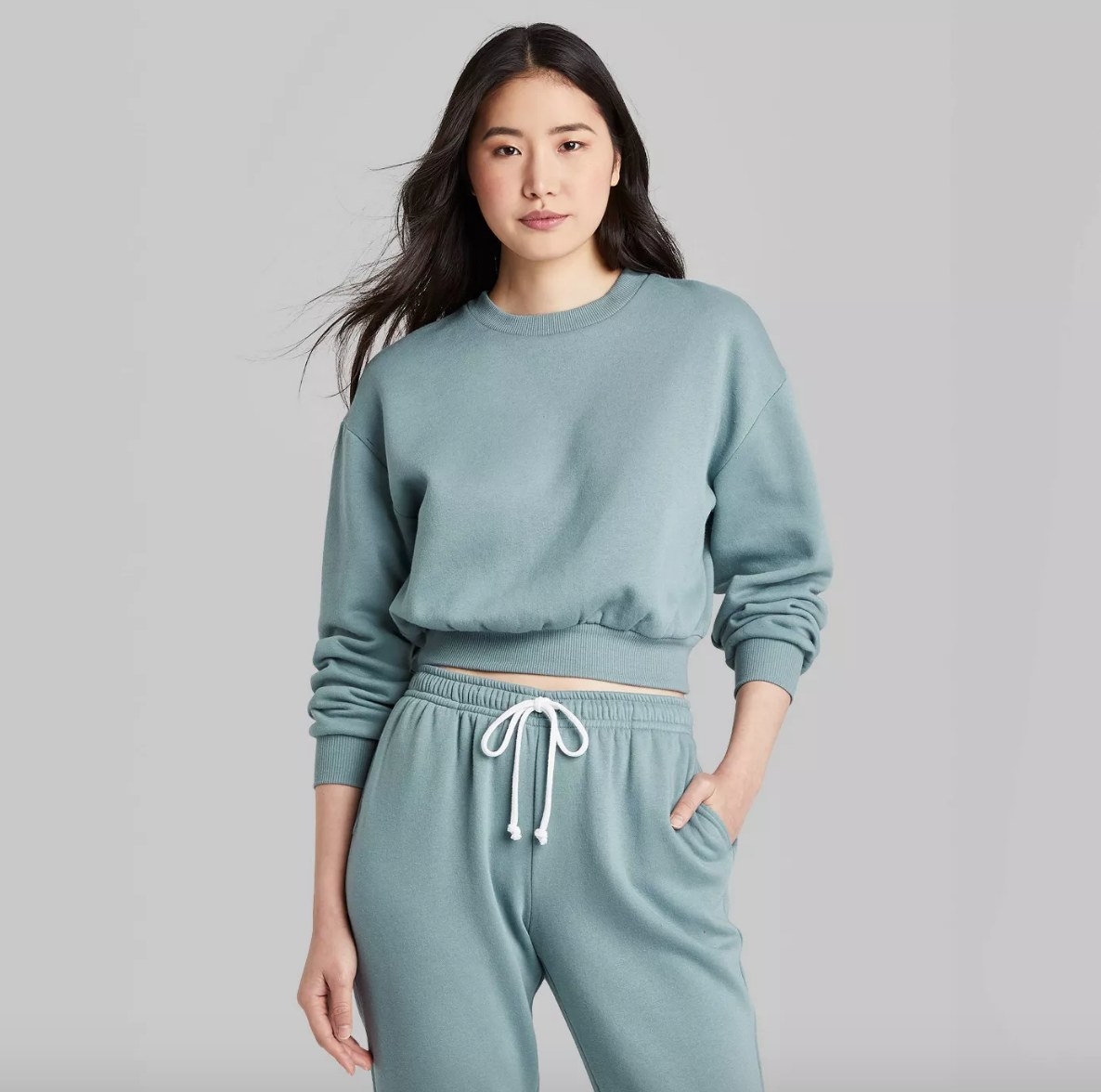 Model wearing blue cropped crew neck with matching sweatpants