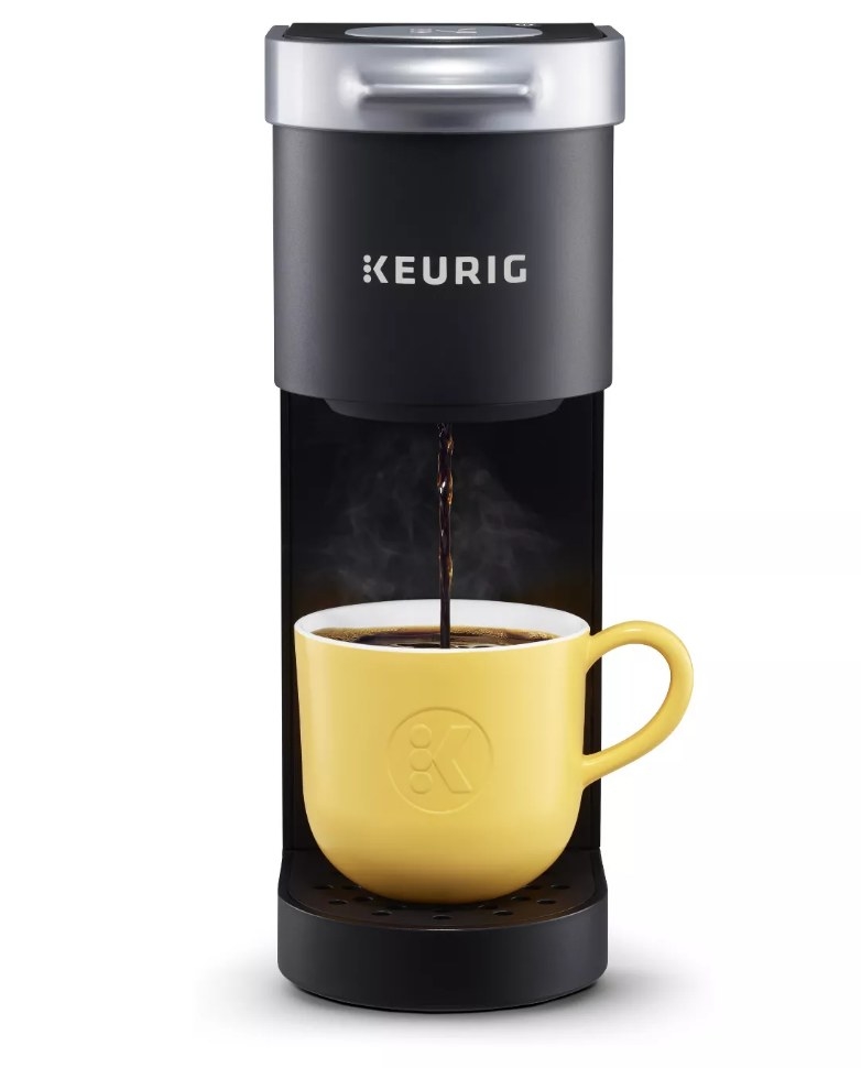 Black Keurig Mini pouring coffee into yellow mug