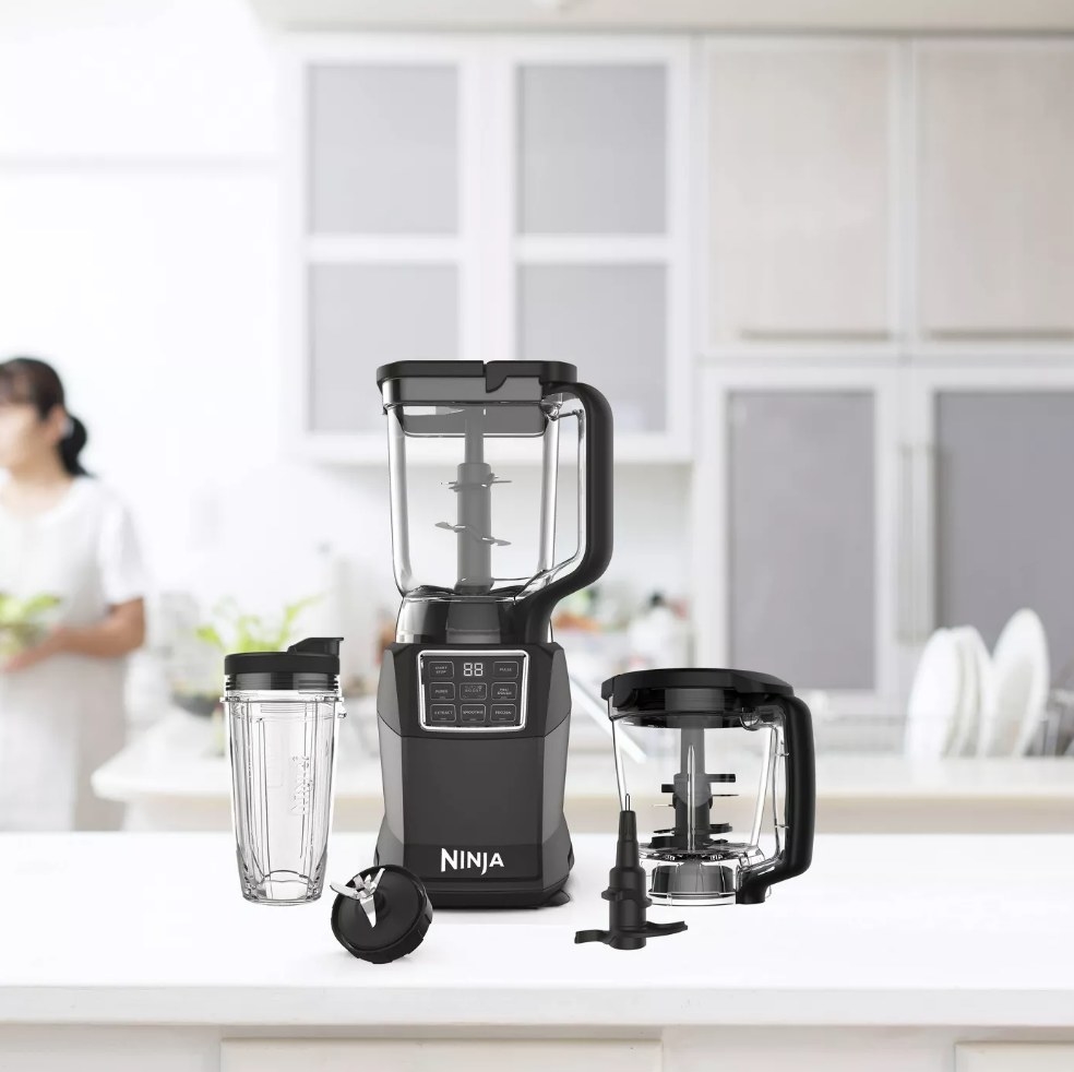 Black Ninja blender base with large blender processor on top, mini blending cup on left, and food processor attachment on right