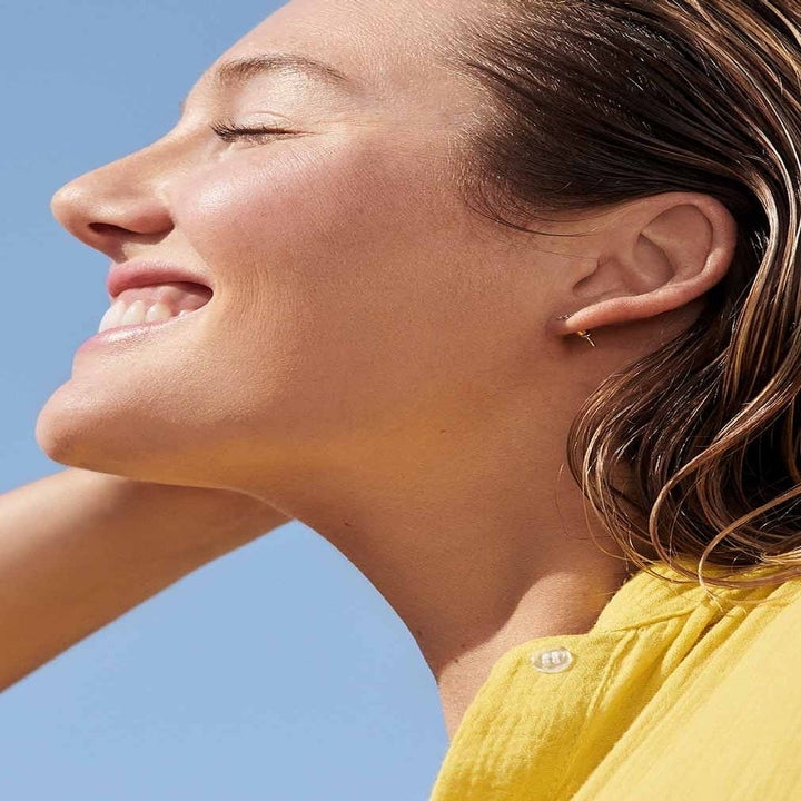 side shot of a smiling model with glowy skin