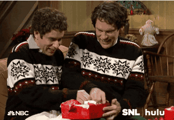 a gif of john malkovich and fred armisen in christmas sweaters excitedly unwrapping gifts