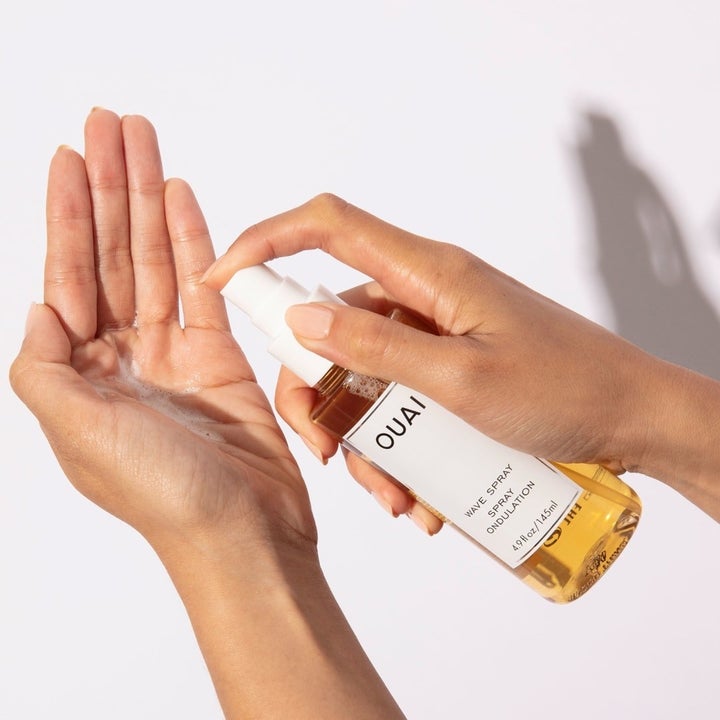 model using pump bottle to dispense the spray in their palm