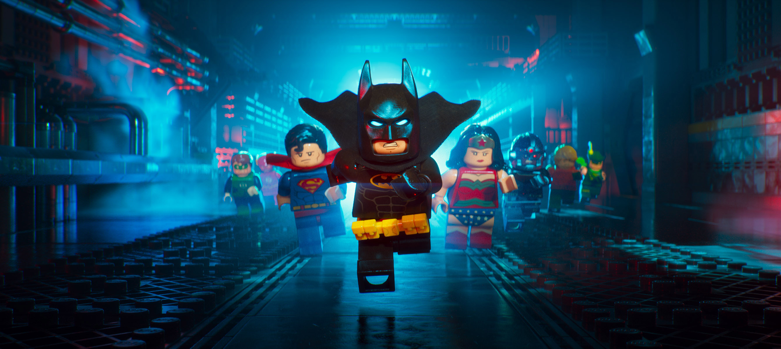 Lego Batman running down a street with Superman and Wonder Woman behind him