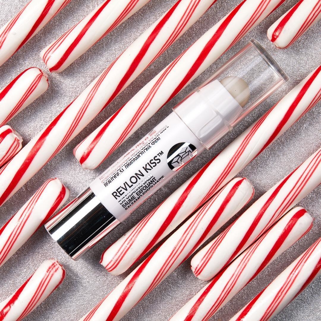 a tube of the exfoliating balm next to several candy canes