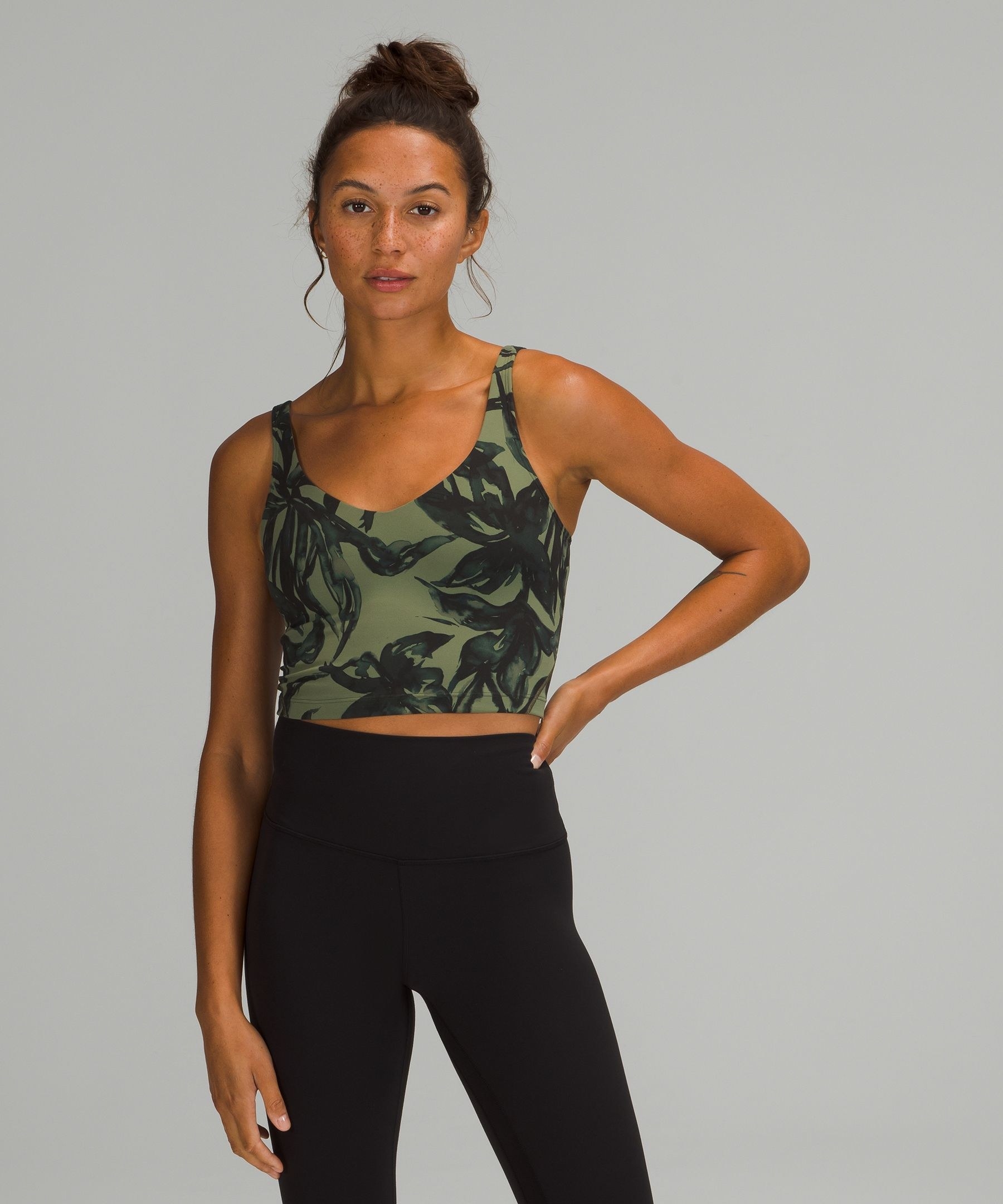 A model in a cropped green tank top
