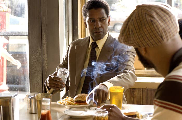 Denzel sits at a diner in a suit in the film