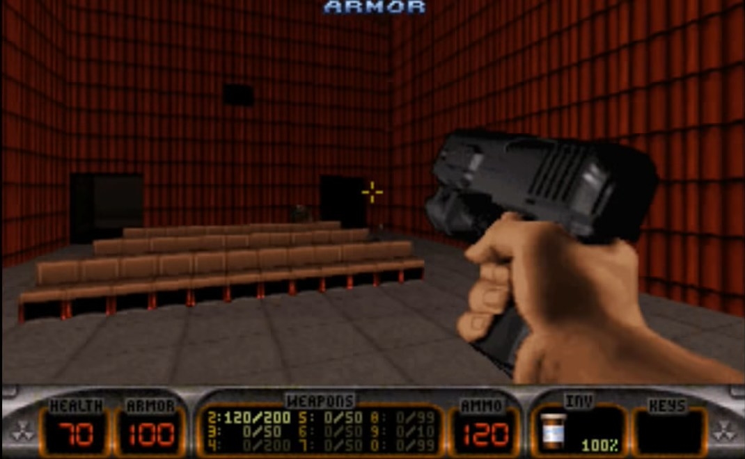 A screenshot of Duke reloading his handgun in a theater