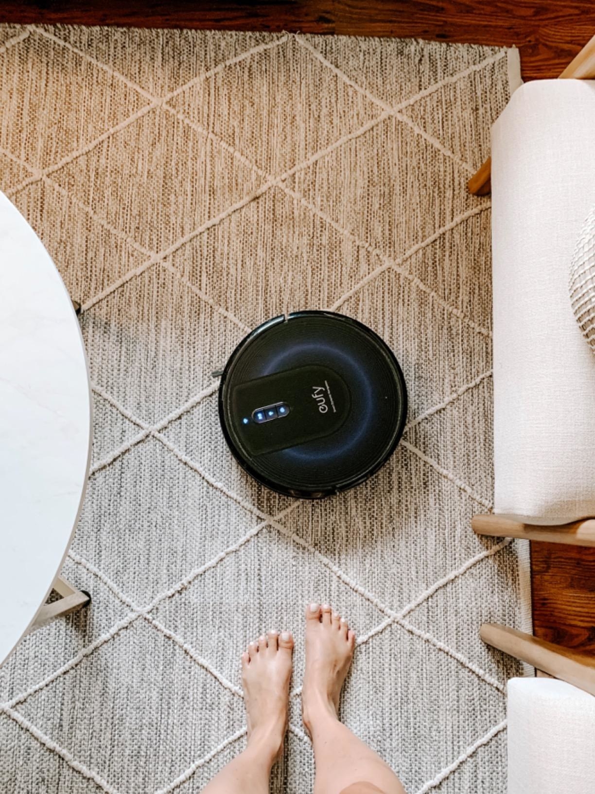 Reviewer&#x27;s Eufy robotic vacuum on area rug