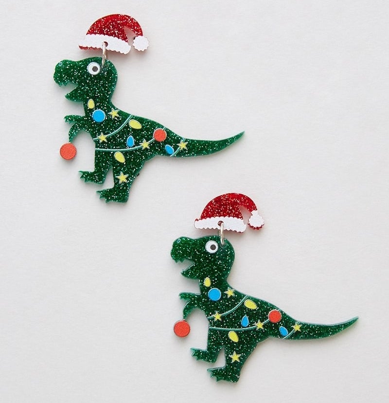 green dinosaurs with santa hats and string lights around their bodies