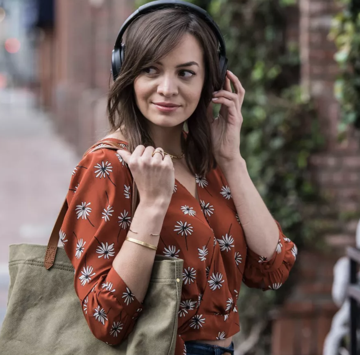 Model listening to music with black over the ear headphones