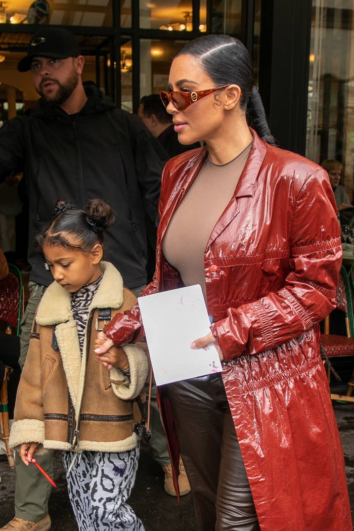 The mother and daughter duo holding hands as they walk out of a building