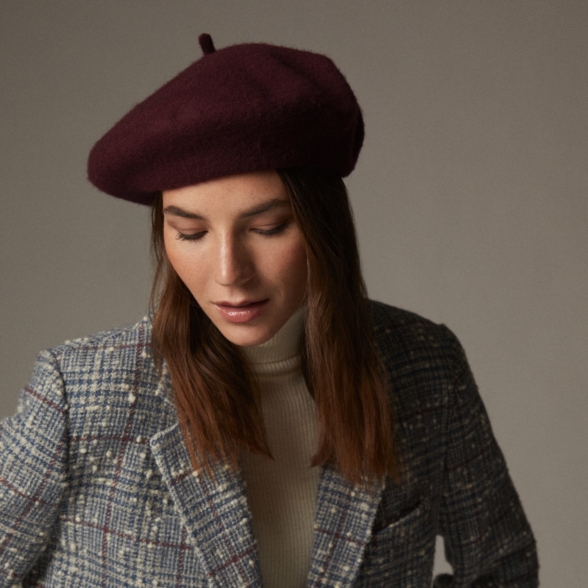 A person wearing a beret with their wool coat