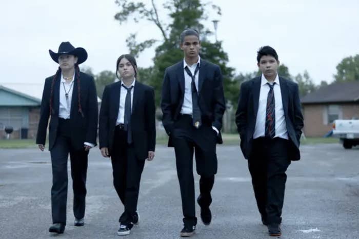 four characters in suits walking solemnly