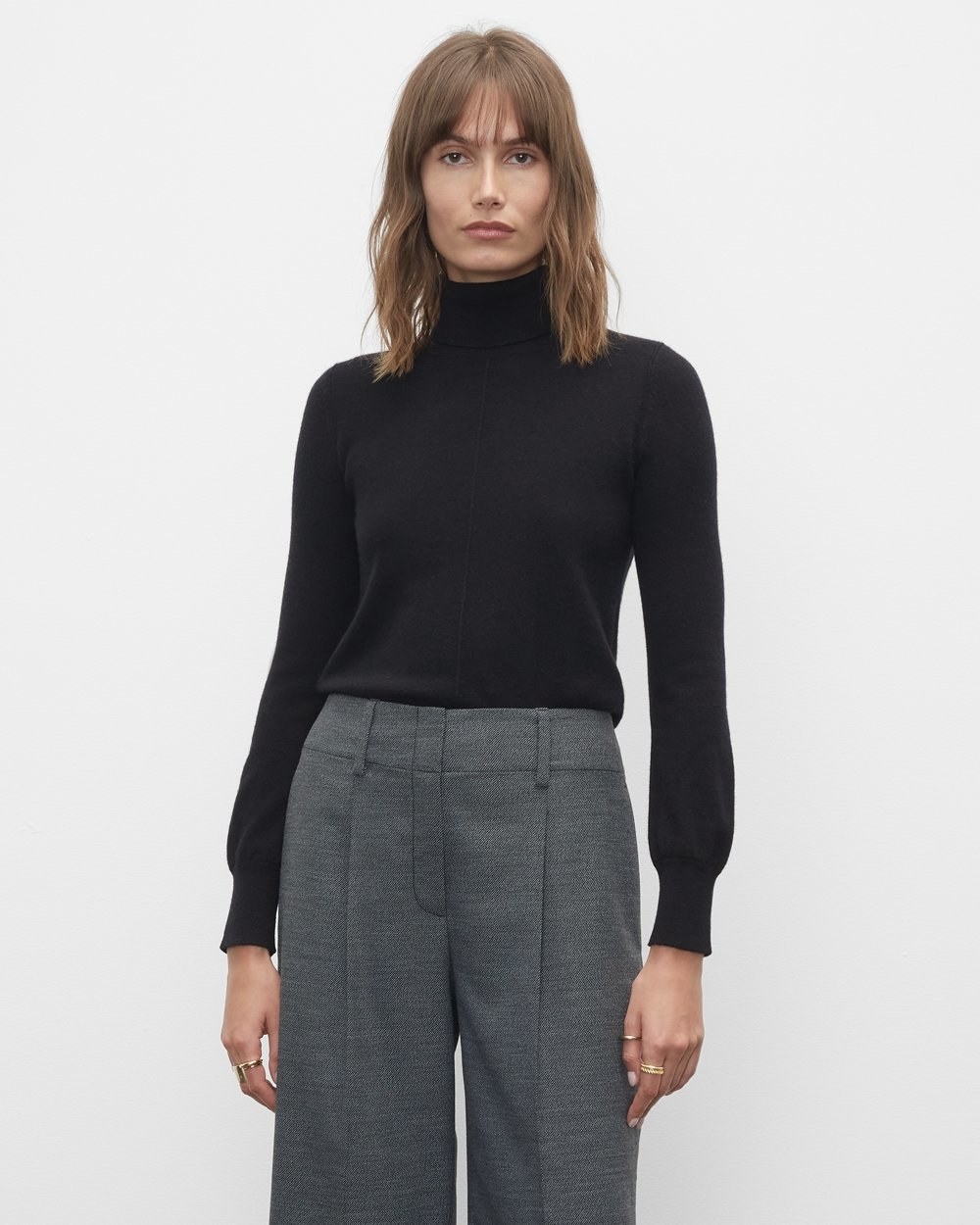 A person wearing a turtleneck with work pants