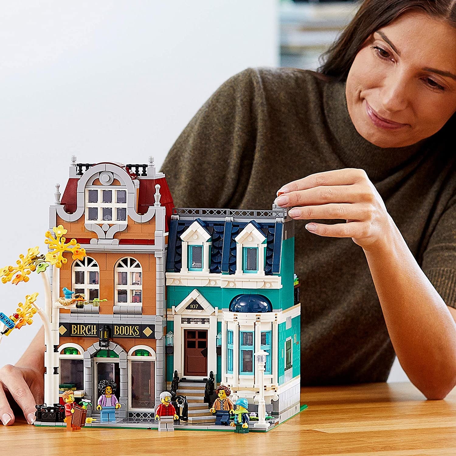 A person playing with the bookshop Lego set