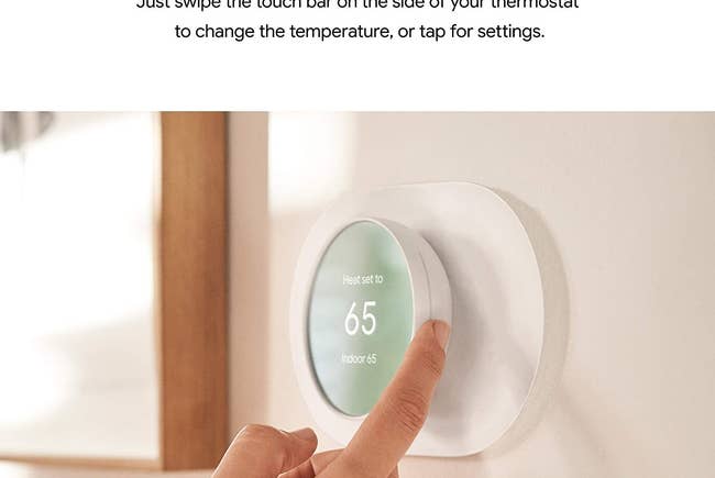 Model adjusting round white thermostat with screen display attached to a wall