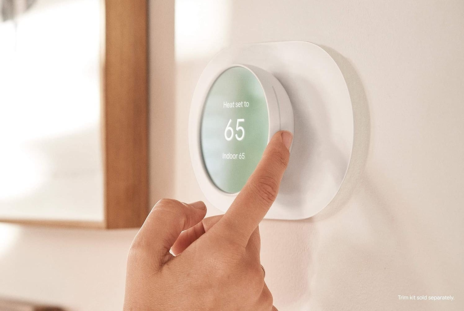 Model adjusting round white thermostat with screen display attached to a wall