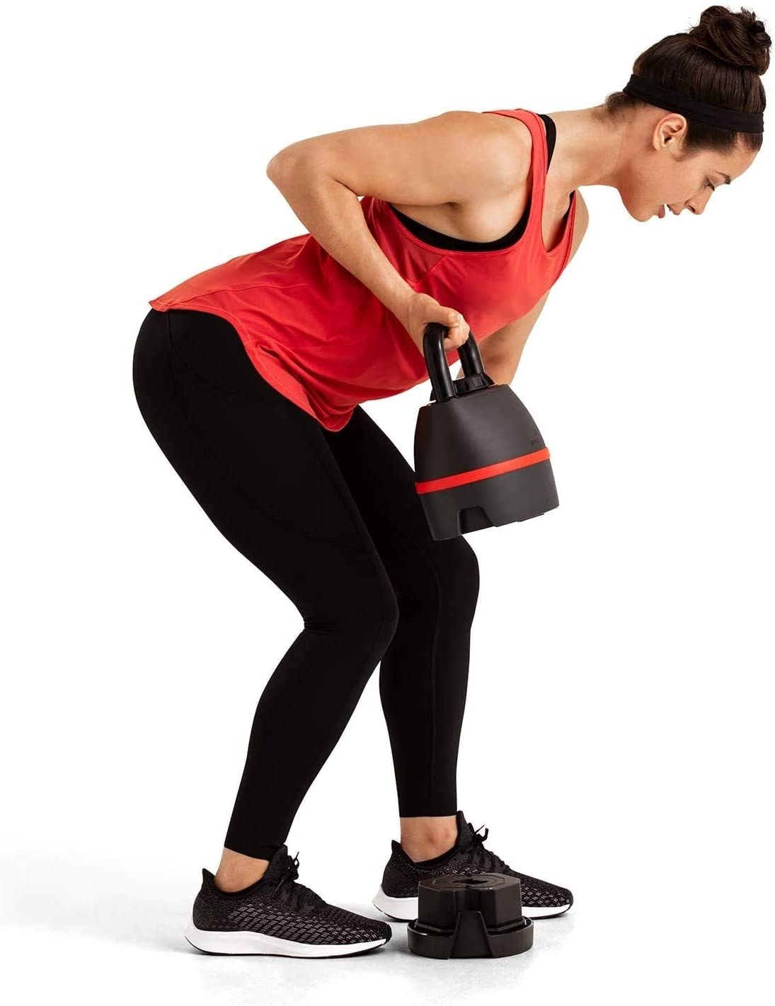 A model lifting a Bowflex kettlebell off the ground to work their arm