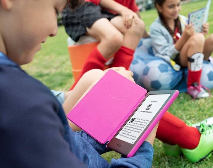 kid reading from a kindle kid with a pink cover