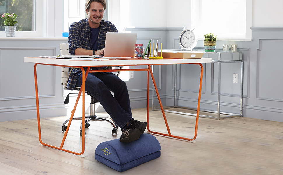model uses blue foot rest to prop feet up while working at a desk