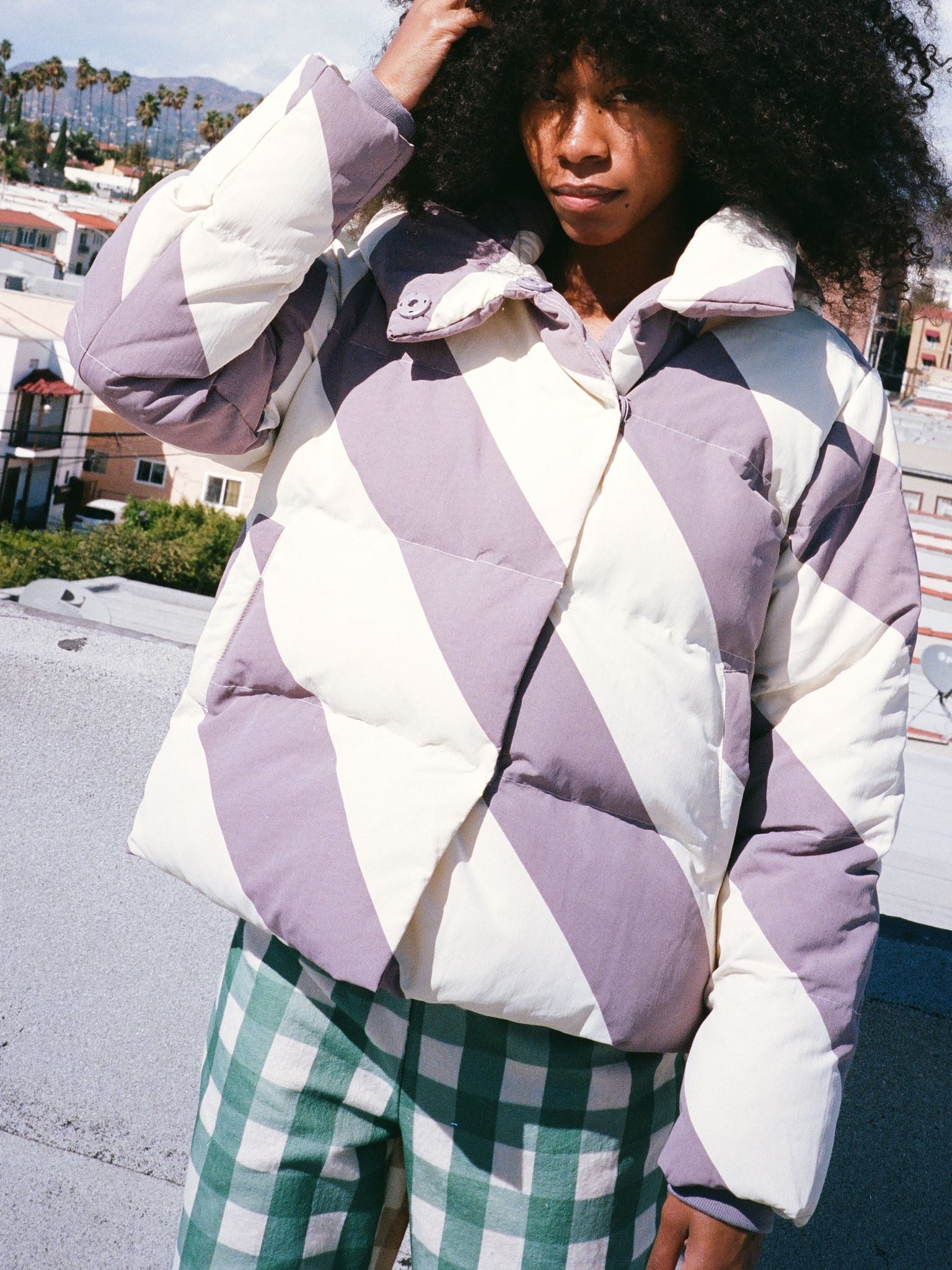 model wearing the lilac and white diagonal stripe puffer jacket