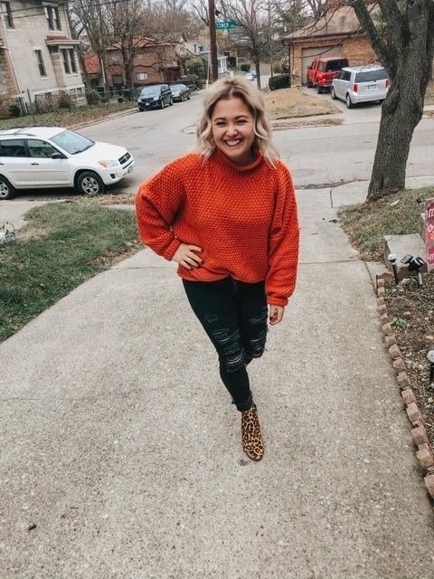 reviewer wearing the sweater in orange