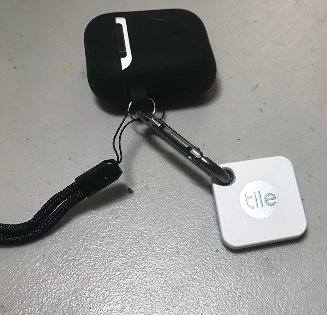 reviewer&#x27;s airpods with a tile tracker connected to them