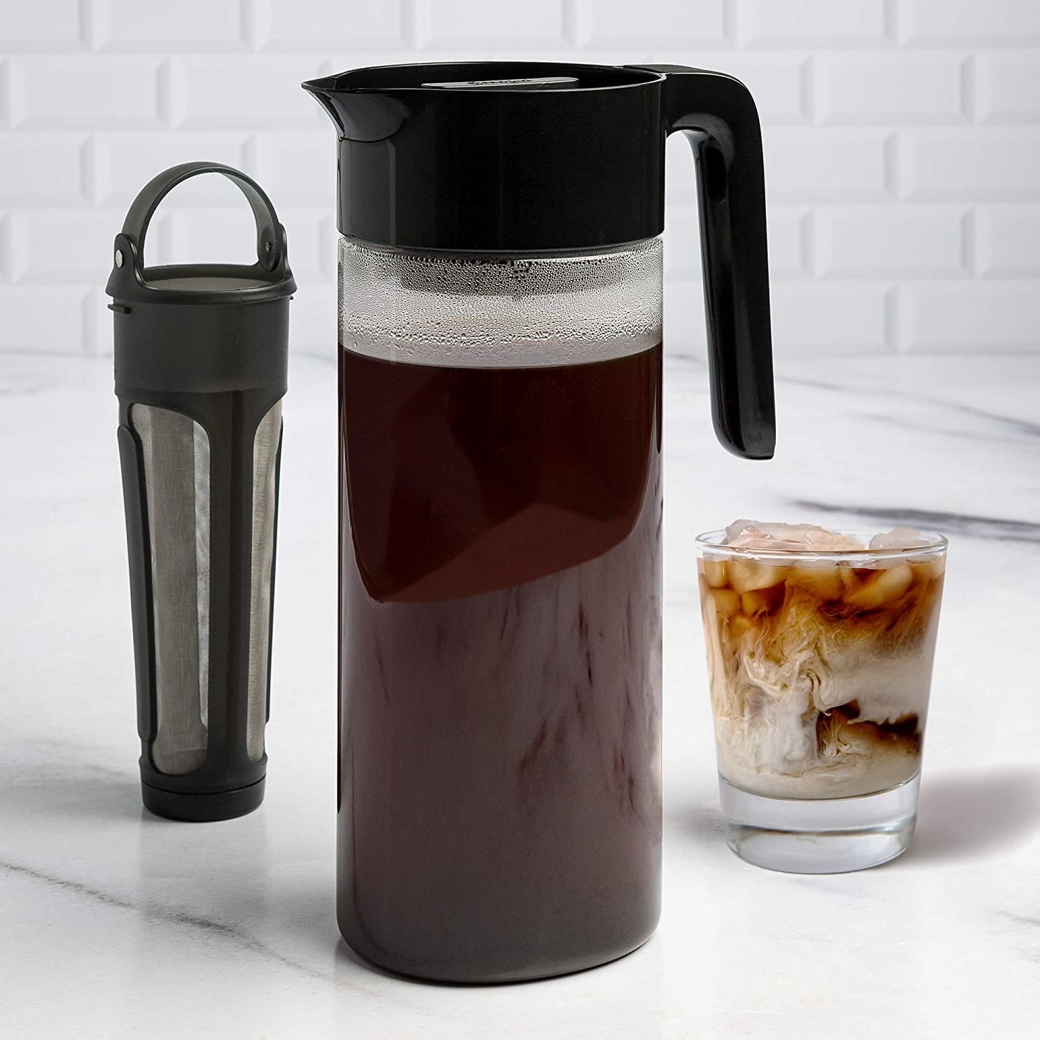 the cold brew coffee maker next to the infuser and a glass of iced coffee