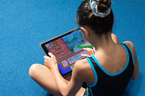 child using a tablet to play the coding game