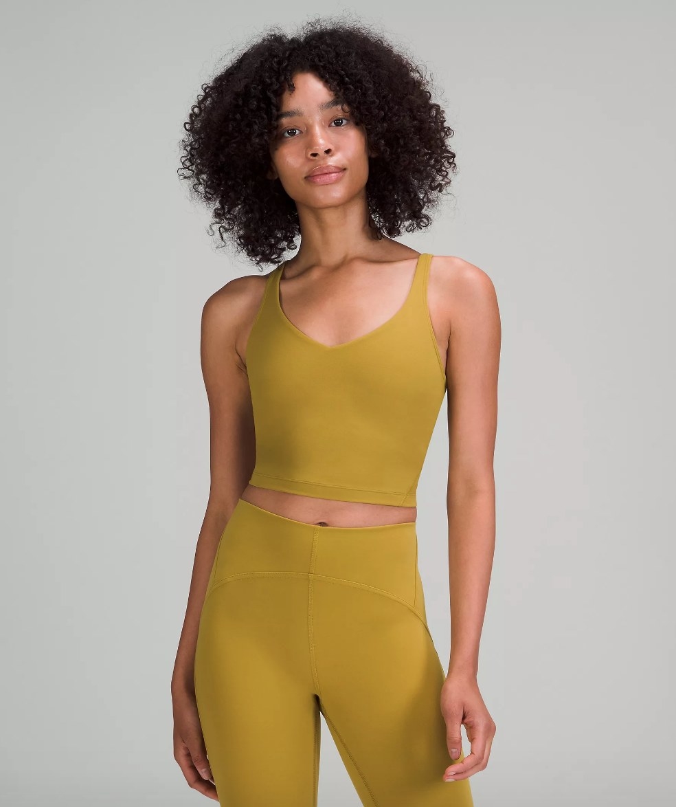 Model wearing mustard colored tank with matching leggings