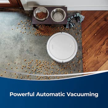 round robot vacuum picking up spilled pet food