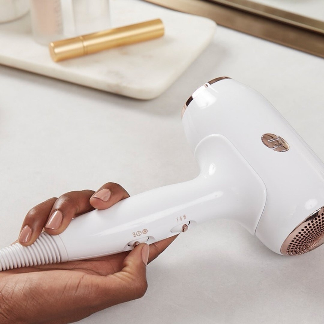 someone holding the compact hair dryer in her hand