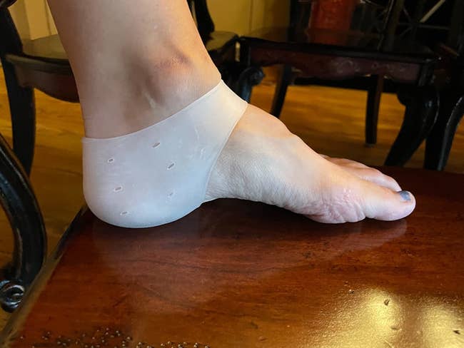 reviewer's foot wearing a silicone heel protector