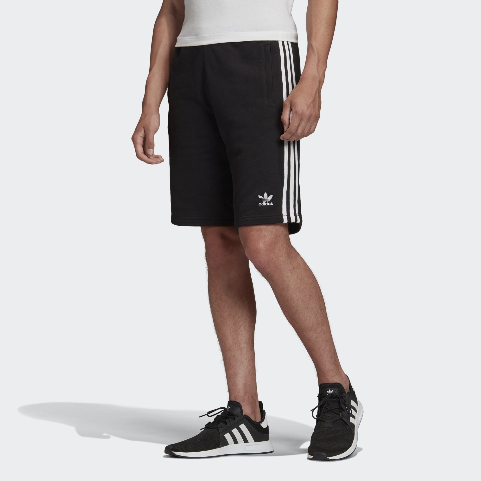 A person wearing shorts and sneakers
