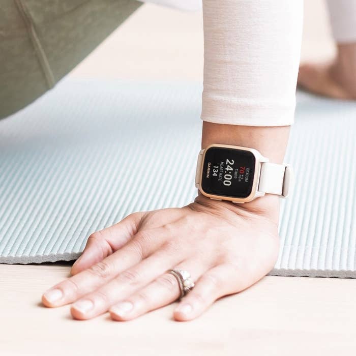 someone wearing the watch on their wrist while leaning on a yoga mat