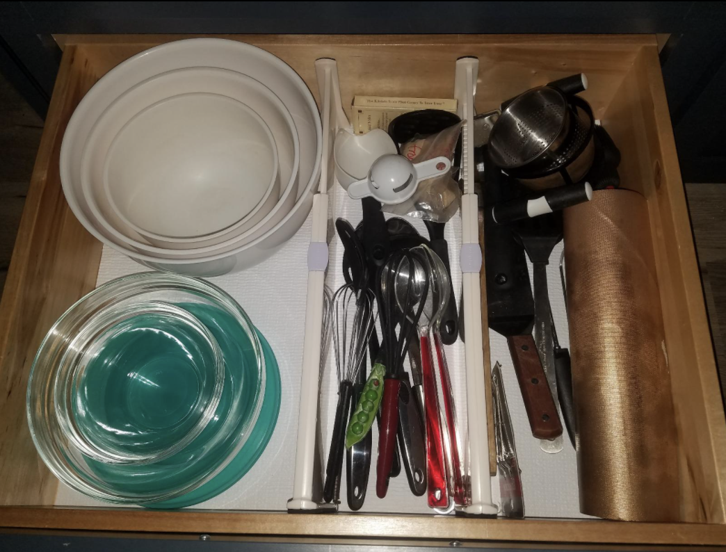 reviewer&#x27;s drawer with a spot for bowls, and two other divided areas filled with baking and serving tools
