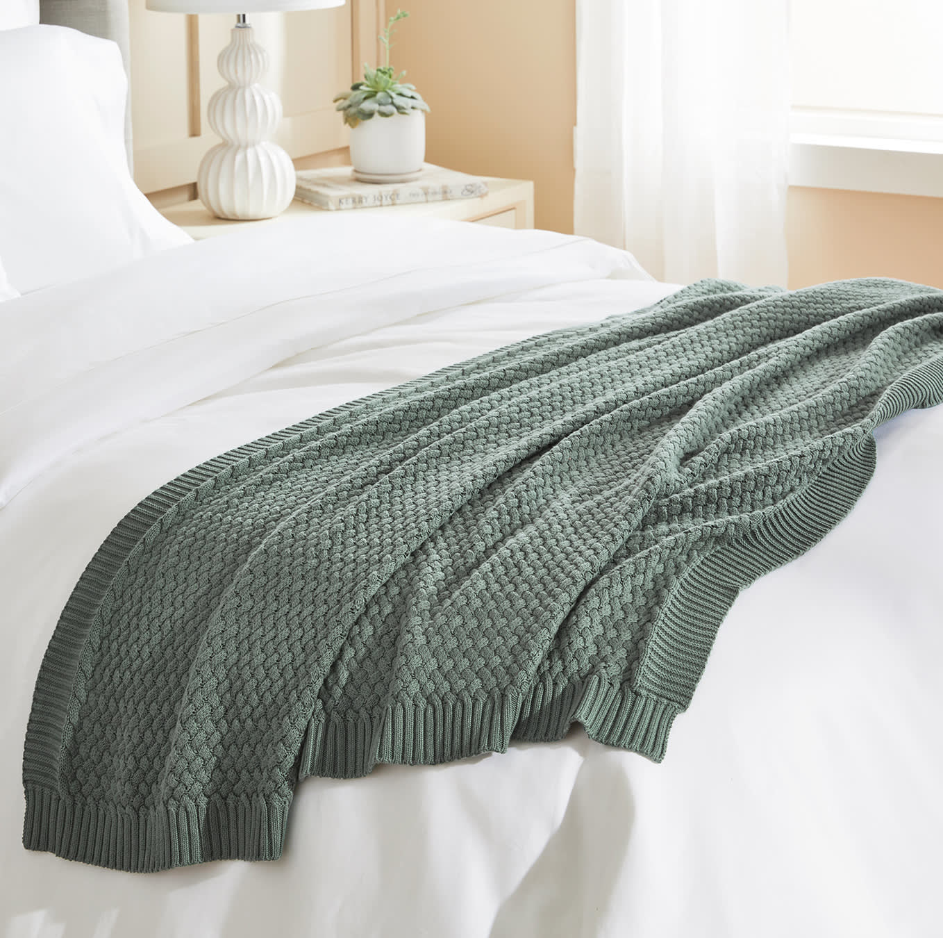 Spruce green knitted blanket atop a bed