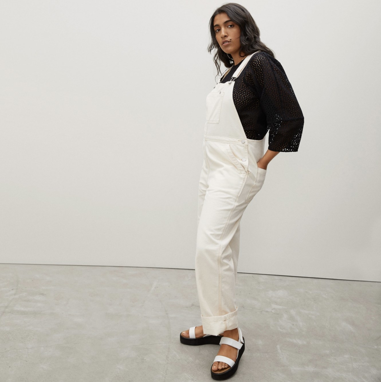Model wearing the white overalls with black shirt and sandals