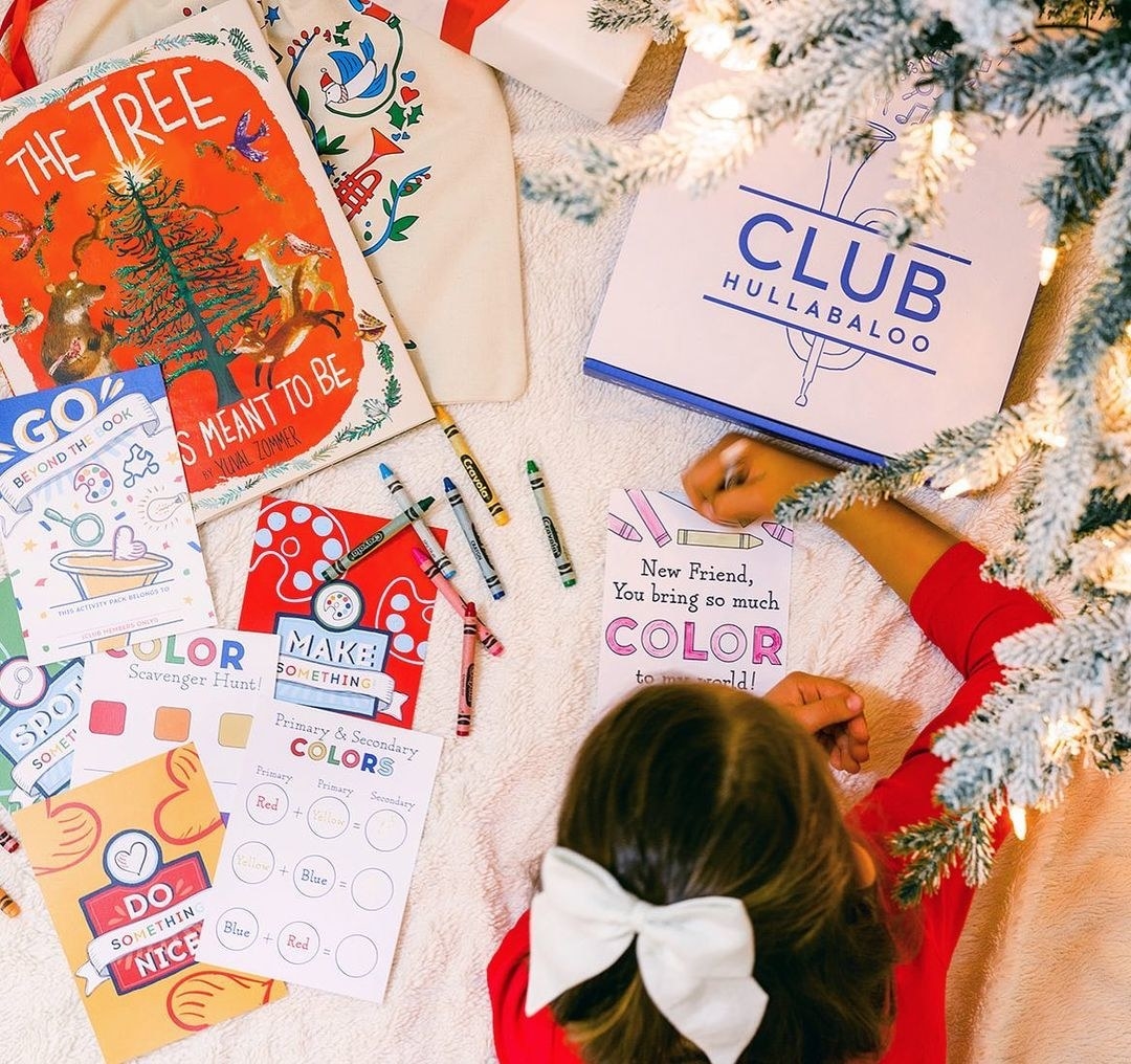 child coloring with activity books and reading books next to them