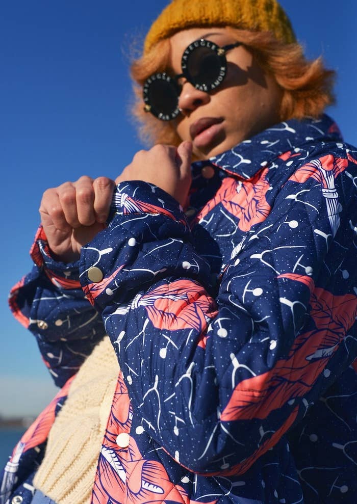 a model ni a blue quilted jacket with pink flowers on it