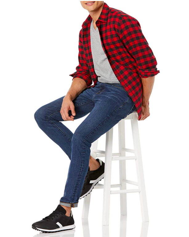 A person wearing a plaid button up shirt with jeans and sneakers