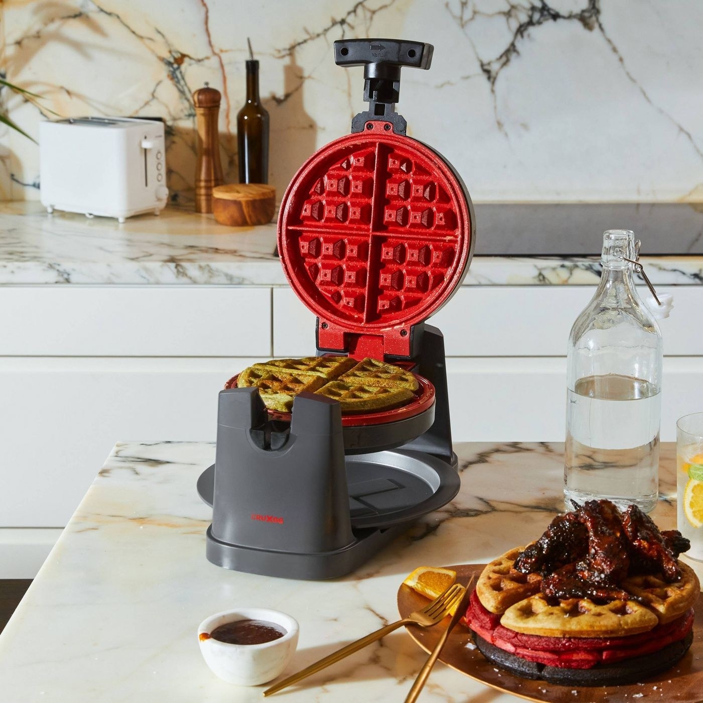 A Belgian waffle sits in a red and grey device, with a stack of beautiful waffles nearby.