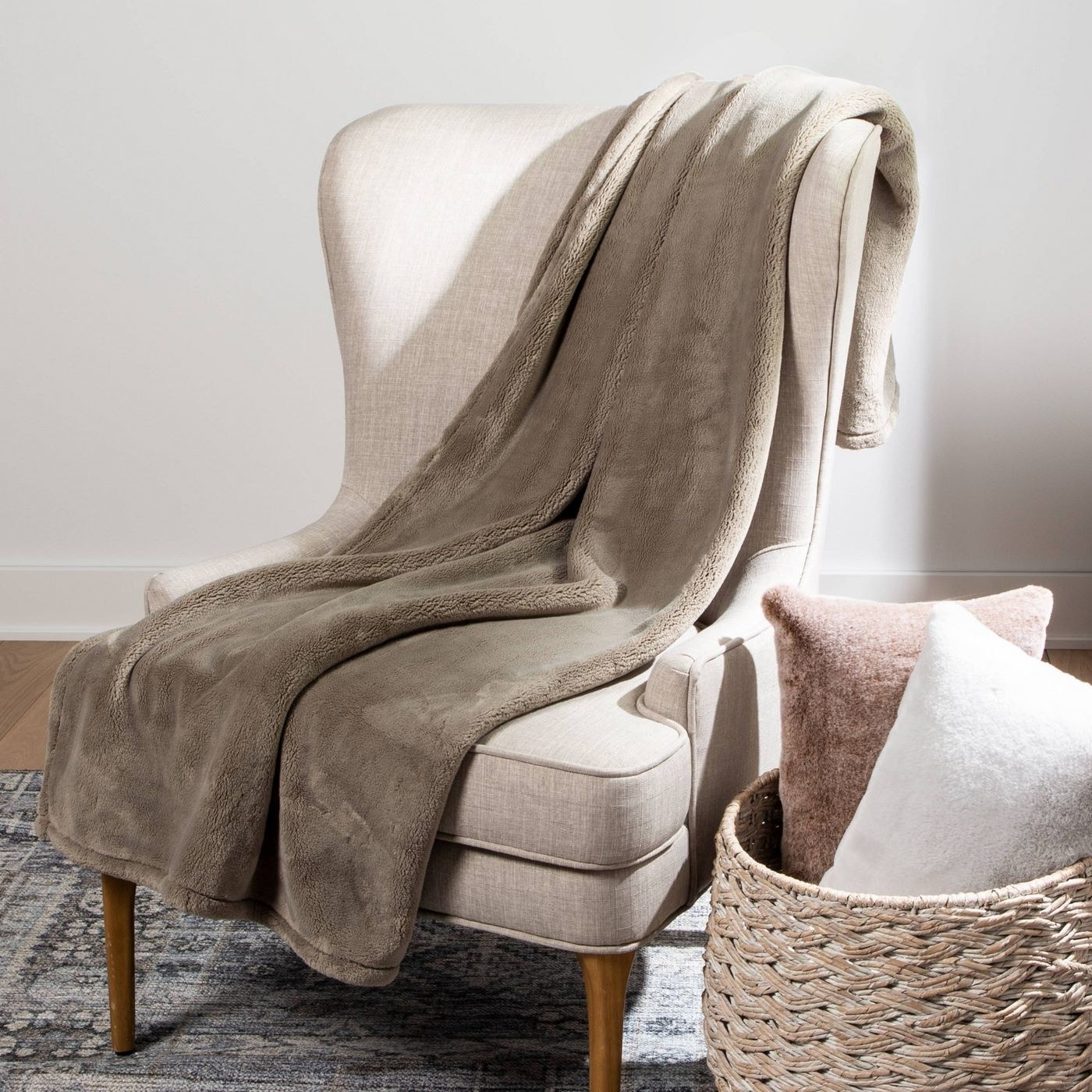 A taupe polyester blanket draped over a cozy chair