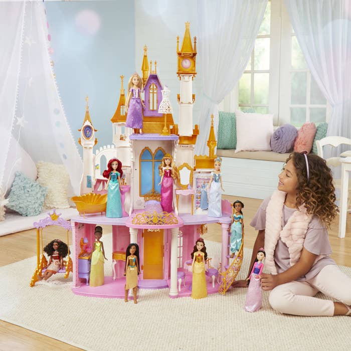a child playing with the disney castle and their disney princess figures