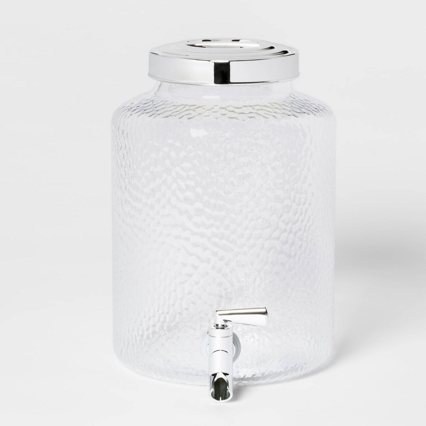 A textured two gallon beverage dispenser with a silver handle to pour out drinks